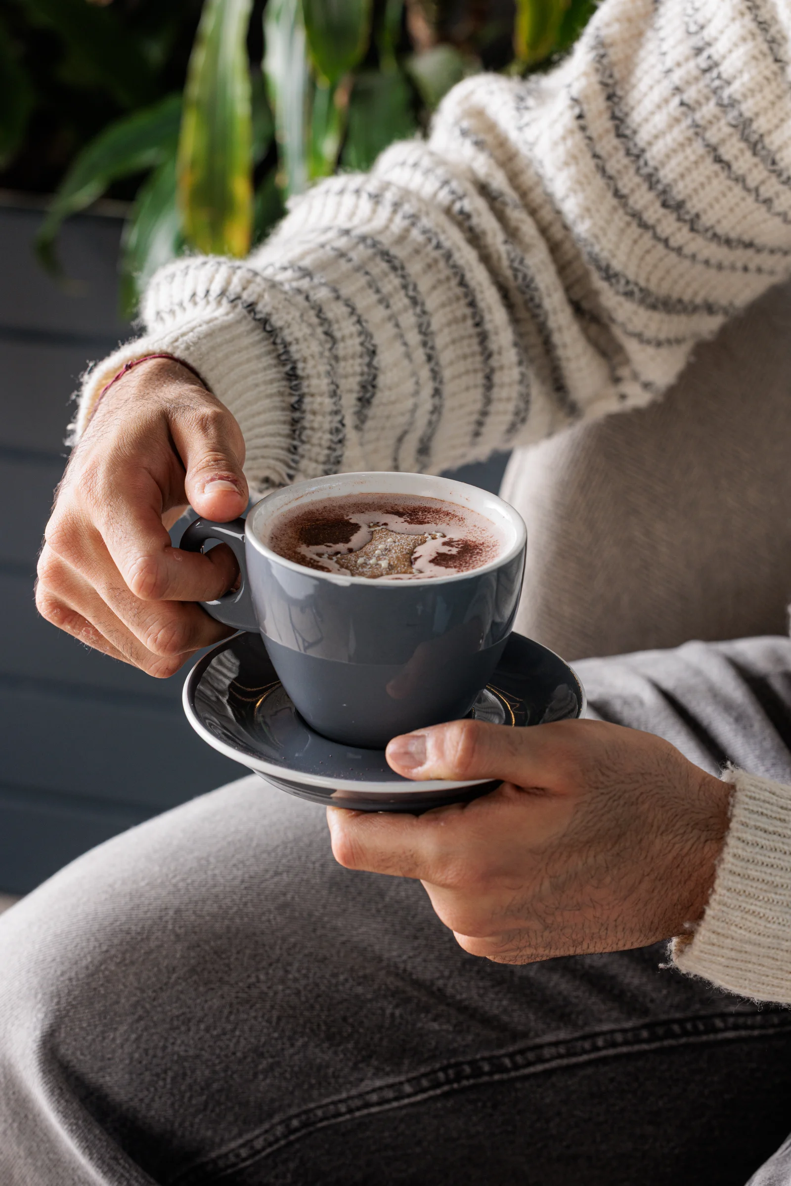 Hands holding a C45 coffee cup and saucer